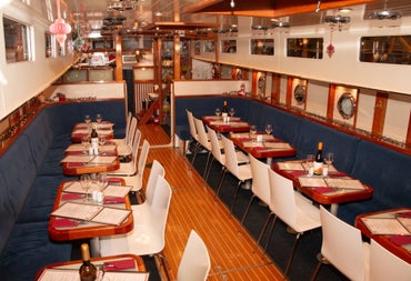 Dining area inside a canal barge with tables laid for service