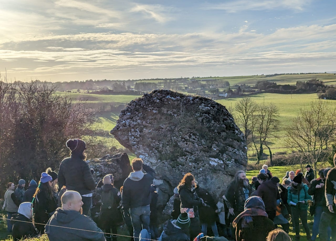 People standing around an ancient stone