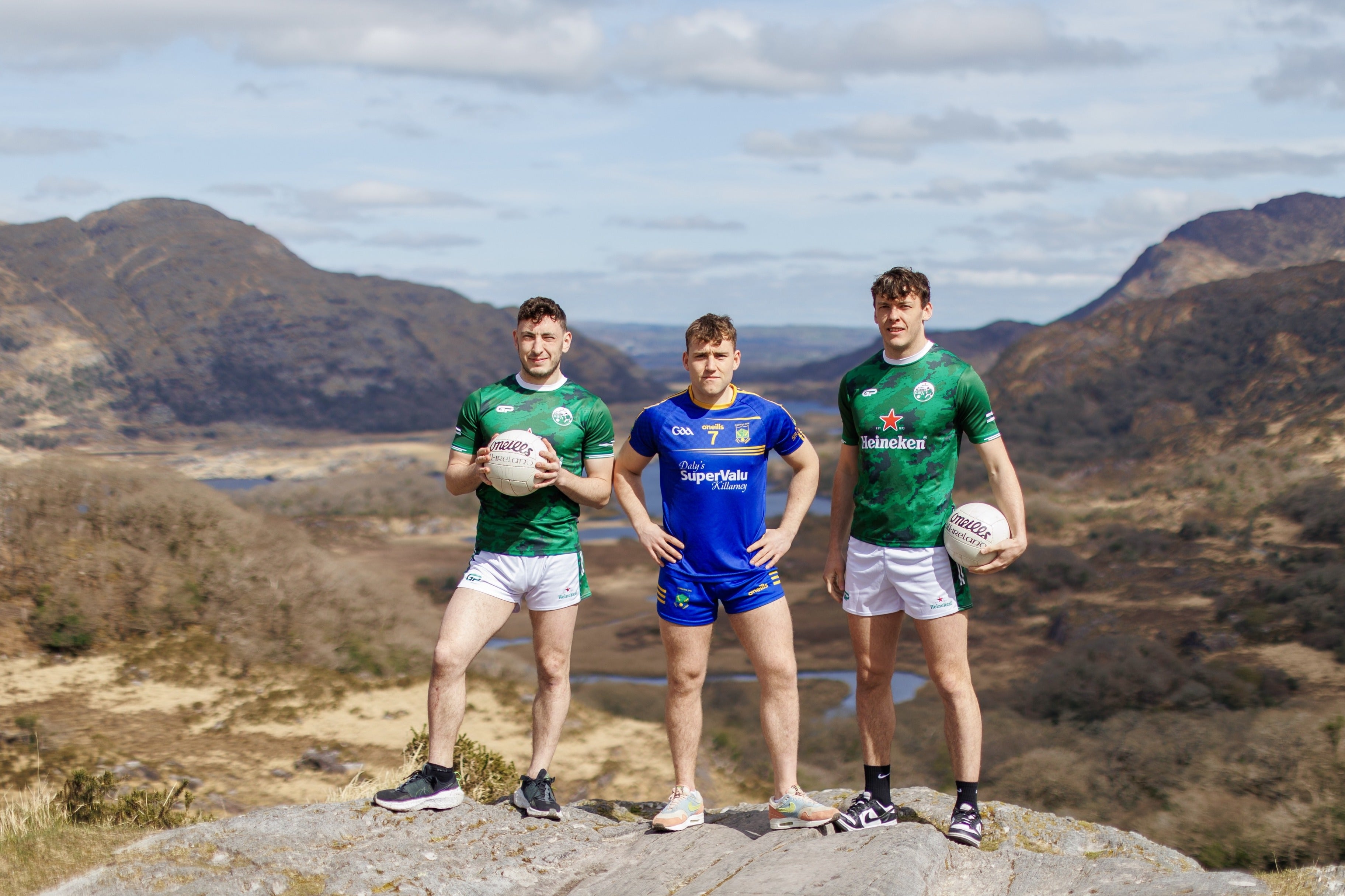 Paudie Clifford, Dara Moynihan, David Clifford - 3 men in club jerseys standing on a rock with rocky hills in the background.