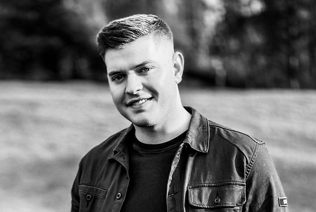 Jack Keogh Dance in the Gleneagle Ballroom. Black and white photo of man slightly smiling, outdoors wearing a jacket.