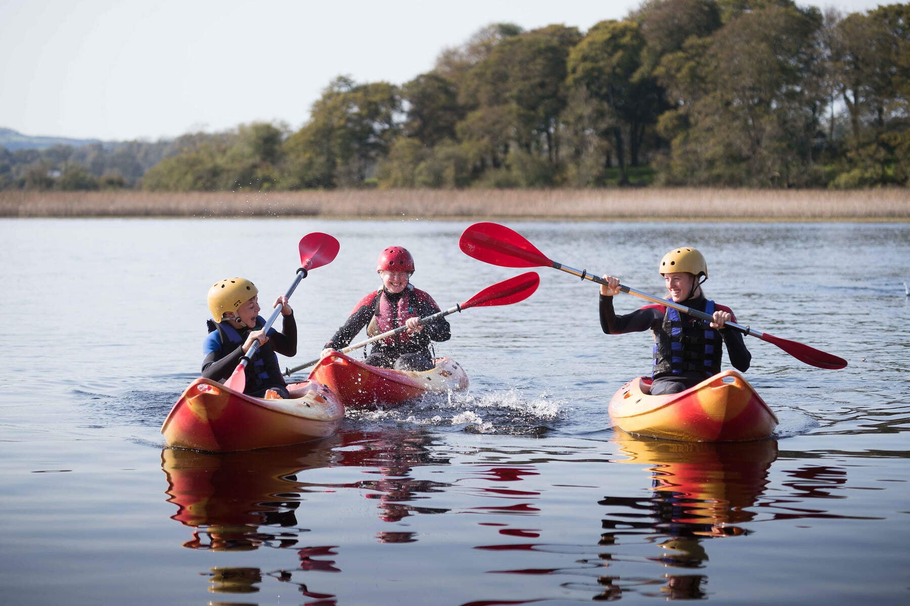 Three people in kayaks on the water