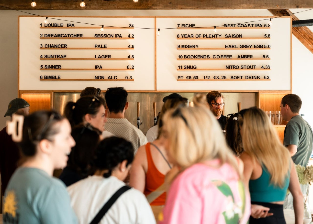 People standing under a drinks menu