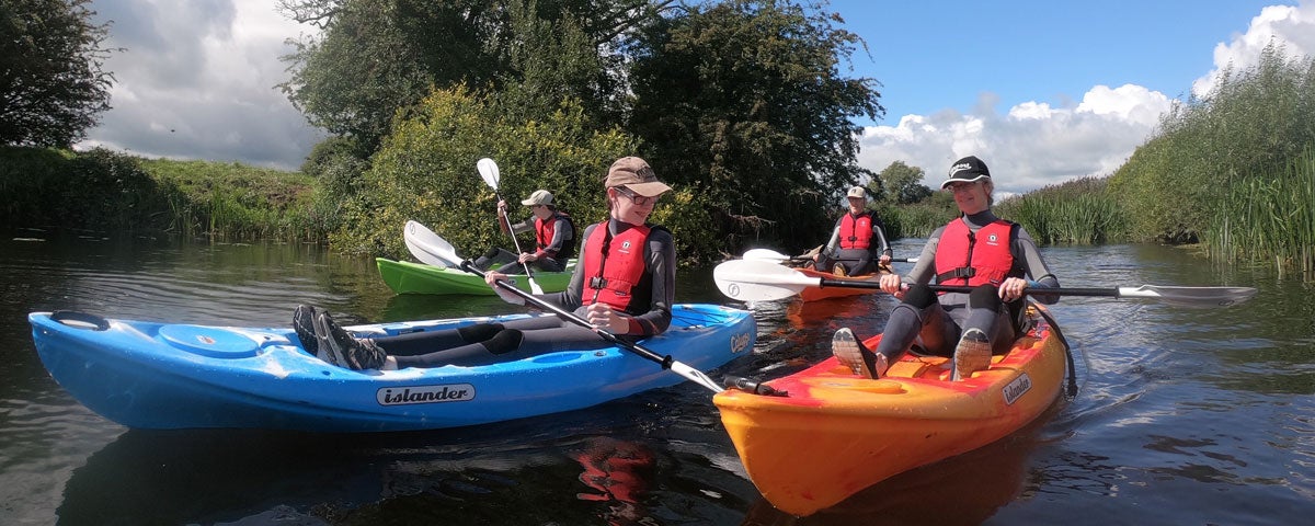 A group of people enjoying a kayak on the river on a sunny day