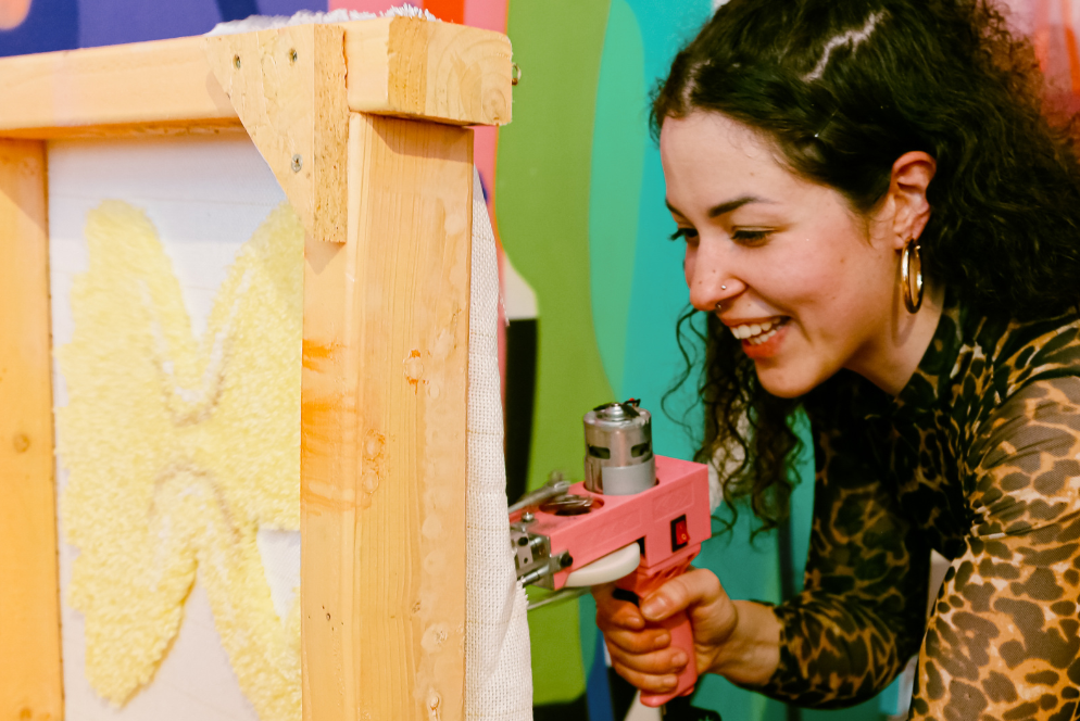 A guest happily tufting a pasta shaped rug on a 40cm frame.