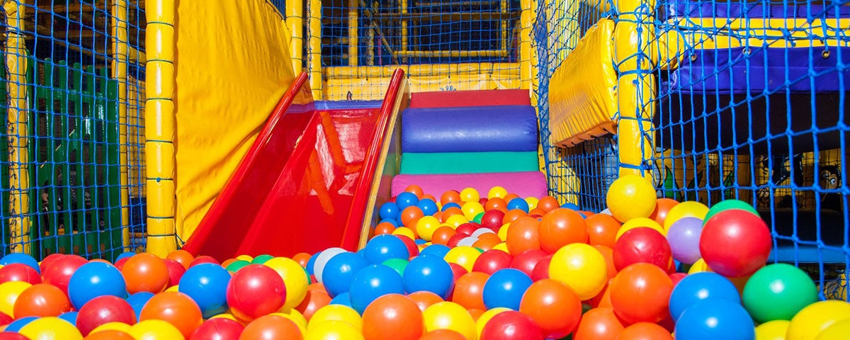 A slide leading down to a ball pool in a kids indoor play area