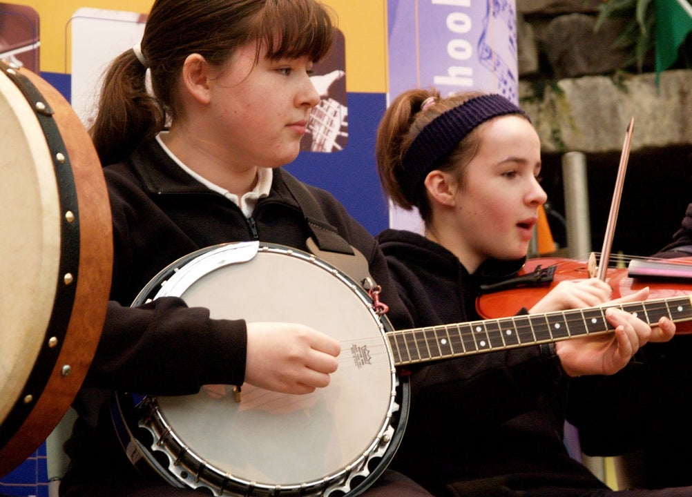 A girl playing the banjo and a girl playing the fiddle at Des Carty Music School