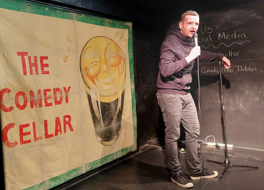 A comedian standing on a stage with a microphone