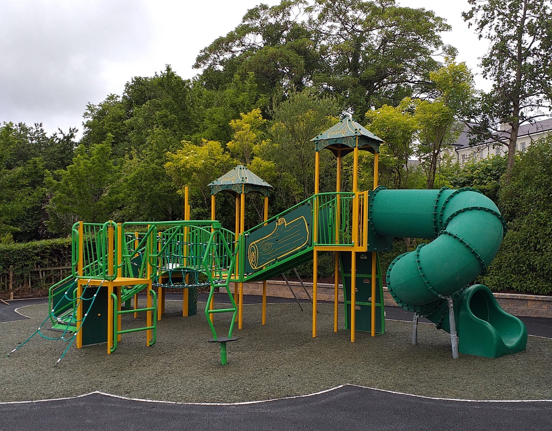Green and yellow multi unit play area for young kids in a playground
