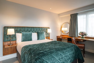 Double bed with green and white sheets