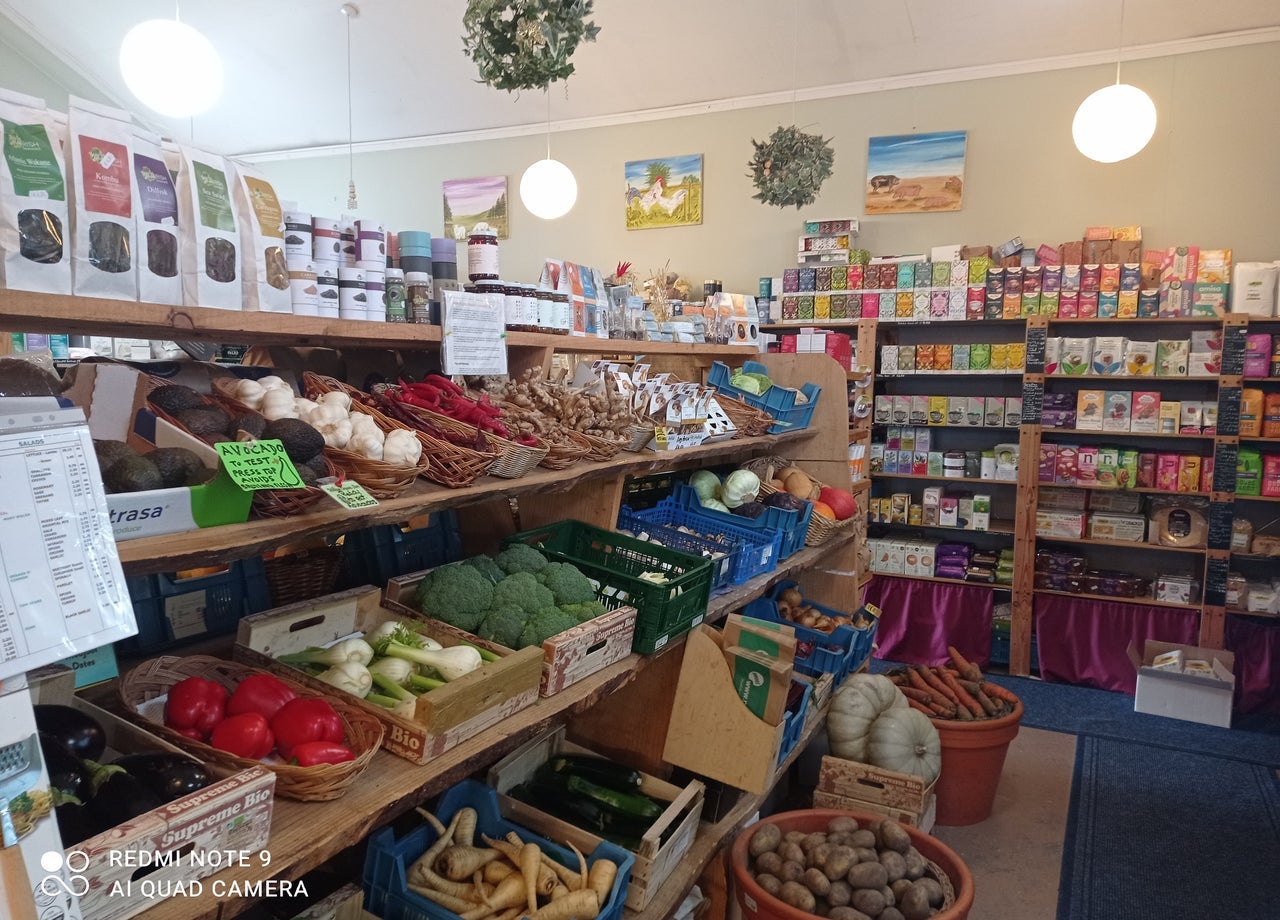 Shelves in a shop with lots of colourful fruit and vegetables along with packaged organic products