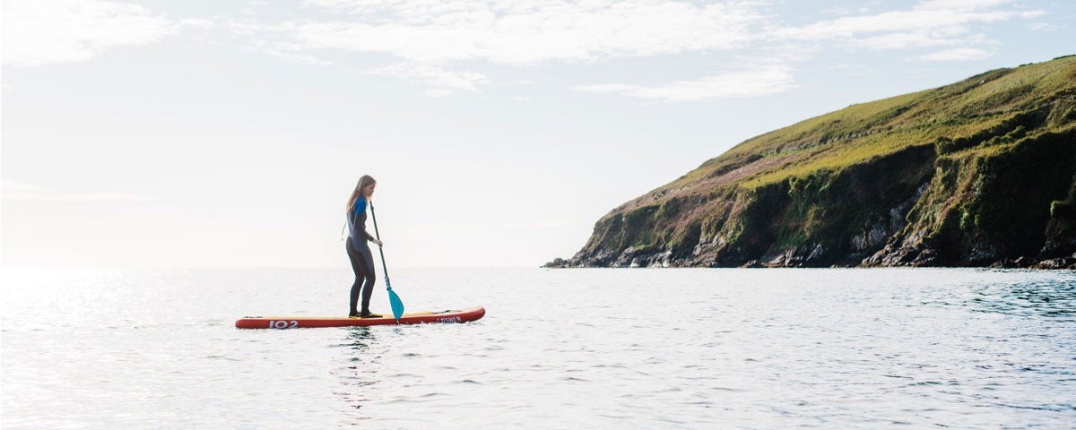 A person on a stand up paddle board out at sea