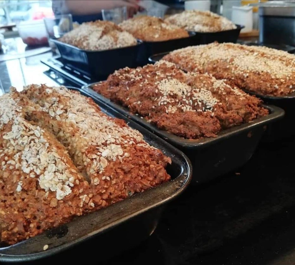 Freshly baked loaf tins of brown bread cooling on racks in the Just Cooking kitchen