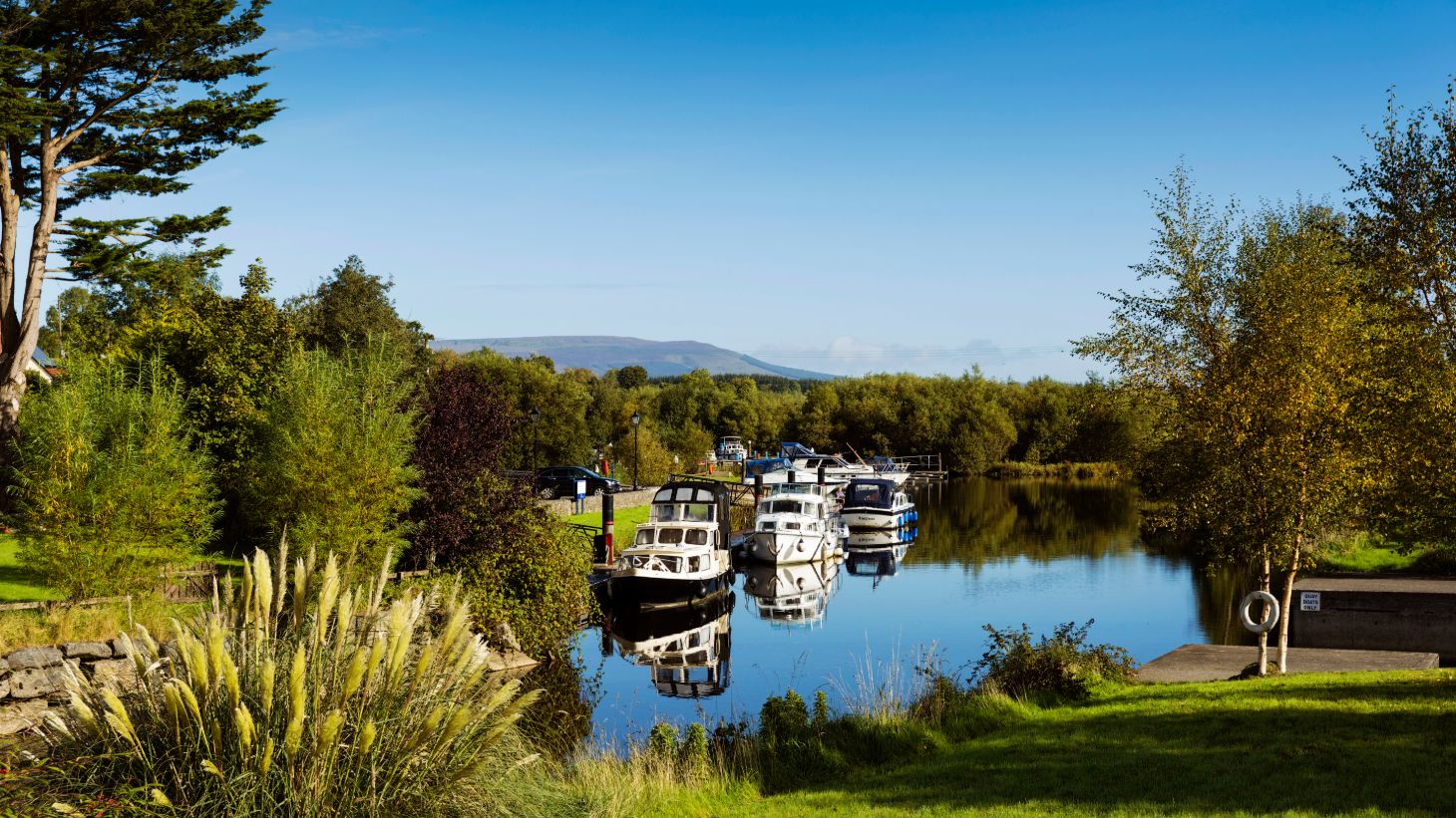 Boats on the River Shannon on a clear day with a mountain in the background
