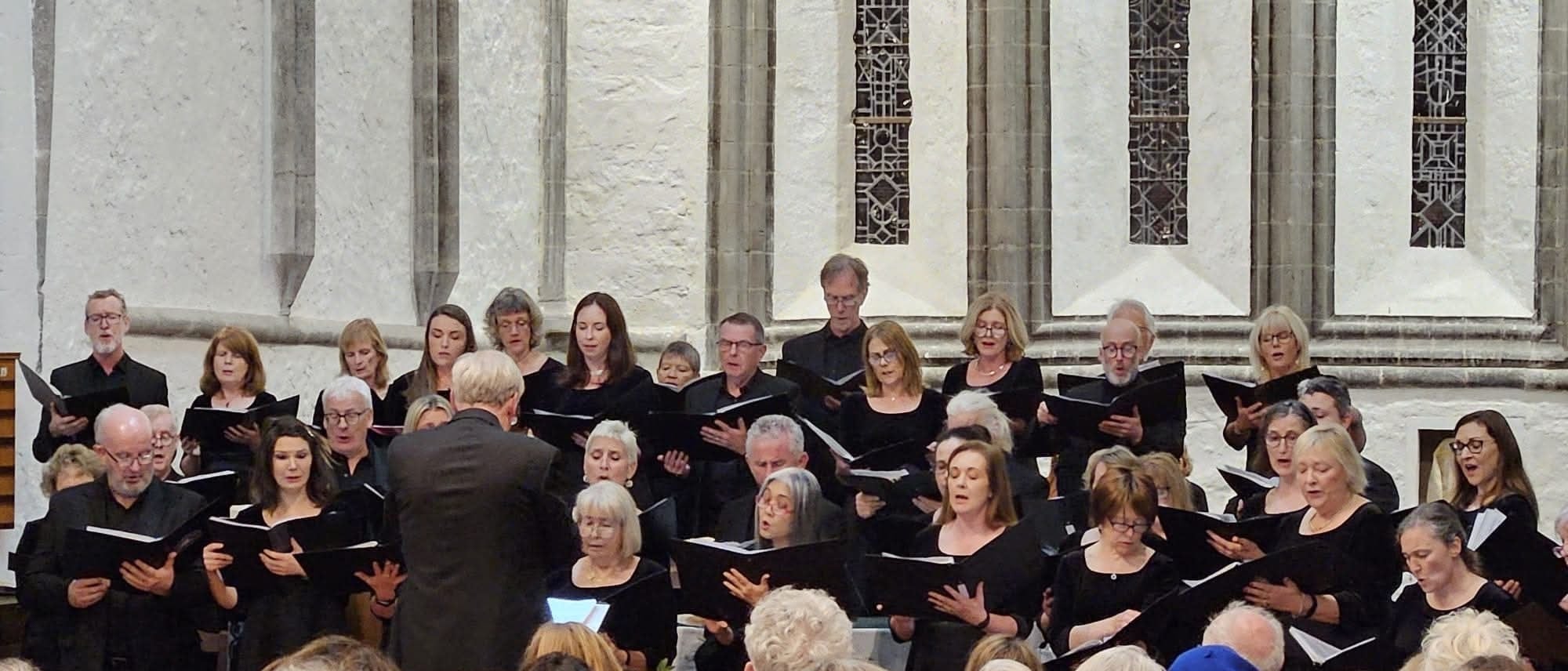 A photo of two choirs, Cór Mhaigh Eo and Louisburgh Voices, in Ballintubber Abbey, Mayo