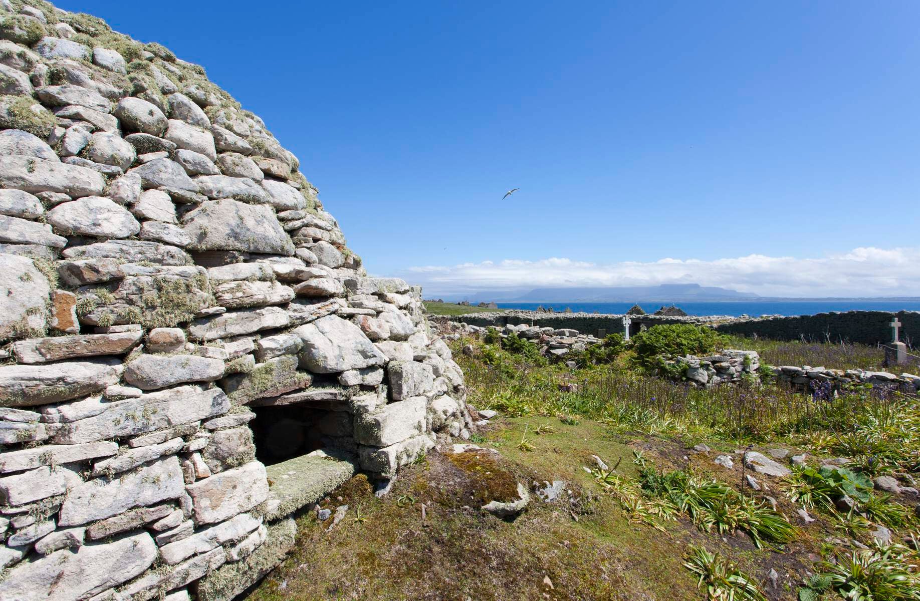 Stone structure with scrub land and sea in the distance