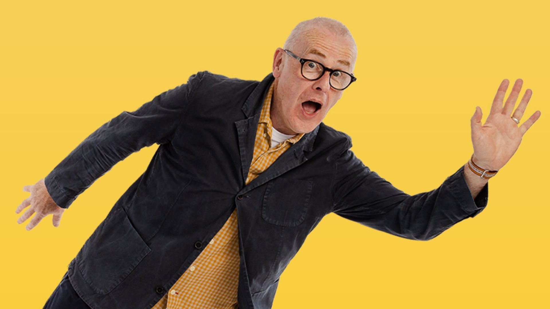 A man with surprised look on face with mouth wide open and arms outstretched, against bright yellow background.