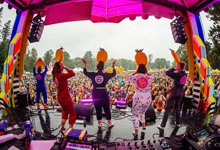 Sing Along Social Gleneagle rear view of people performing on a small outdoor stage with large audience in the background.
