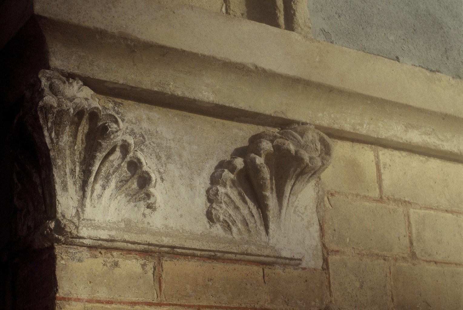 Part of an old, worn building with ornate sculpting.