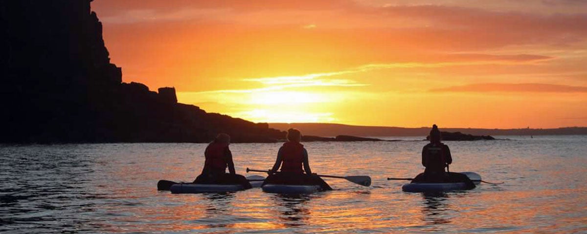 Paddlers in the water watching the sun rise