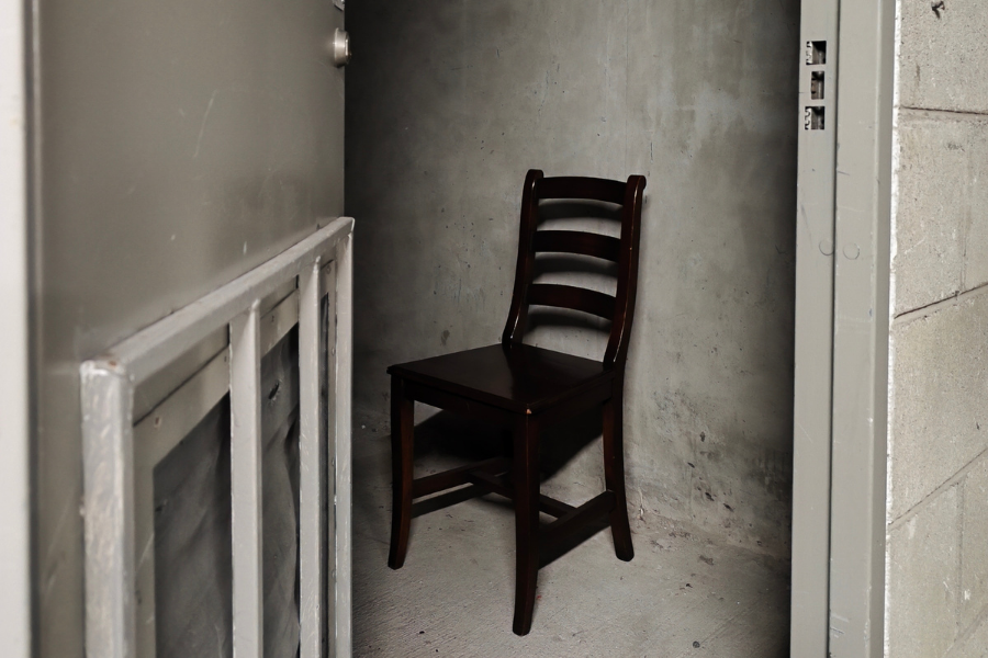 A lone chair in a small, scruffy room