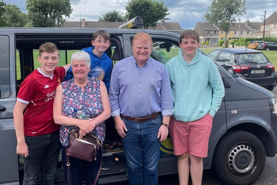 A family group posed at a taxi before they start their Cork City War of Independence tour