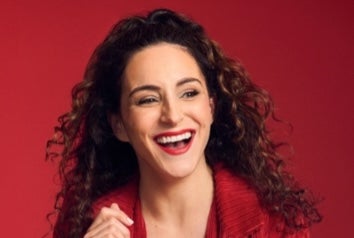 Janine Harouni with This is What You Waited For Tour, a laughing woman in red shirt.