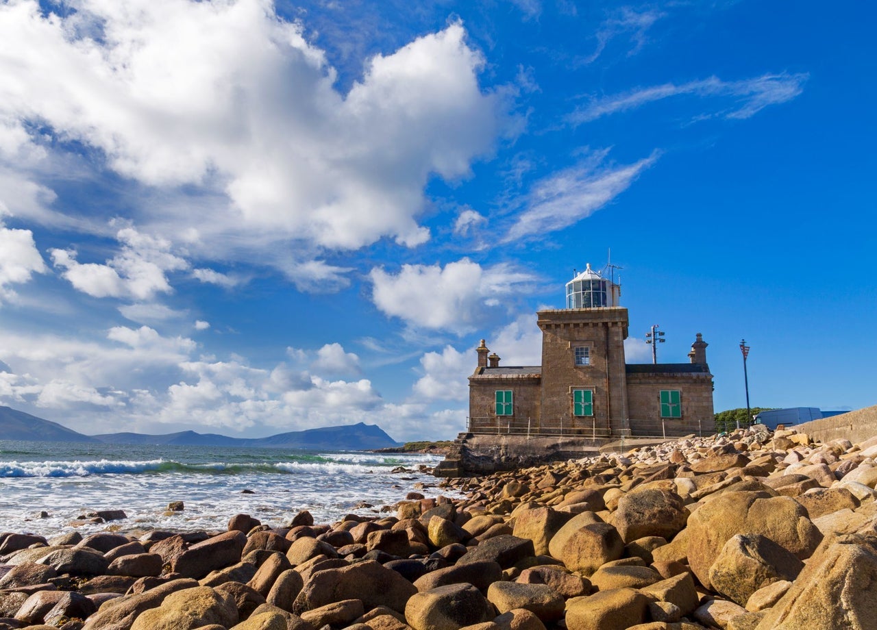 A small lighthouse beside a rocky coastline
