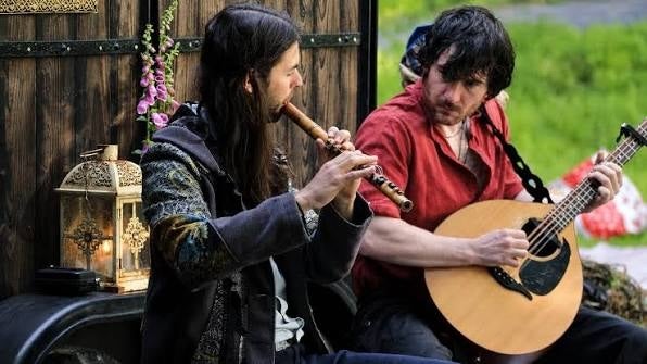 Rennie and Lúan, 2 seated men playing musical instruments.