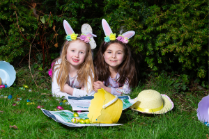 Easter Trail Strokestown Park, 2 young girls laid on grass with easter bunny ears, baskets and eggs