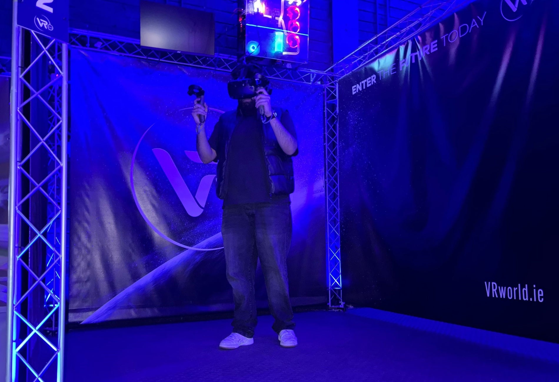 Person standing alone in a dark room using a virtual reality headset