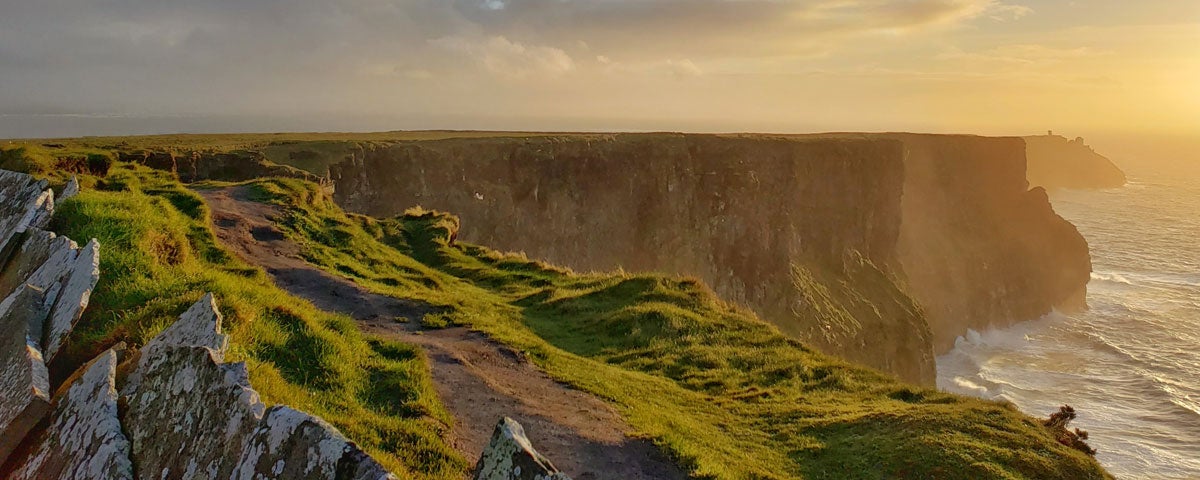 A grassy cliff path along a cliff edge