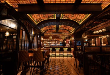 A view of the Whiskey Bar at Murray's Bar & Grill with a striking stained glass ceiling and patterned flooring