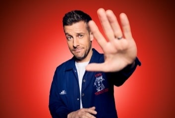 Comedian Chris Ramsey holding one hand out forewards