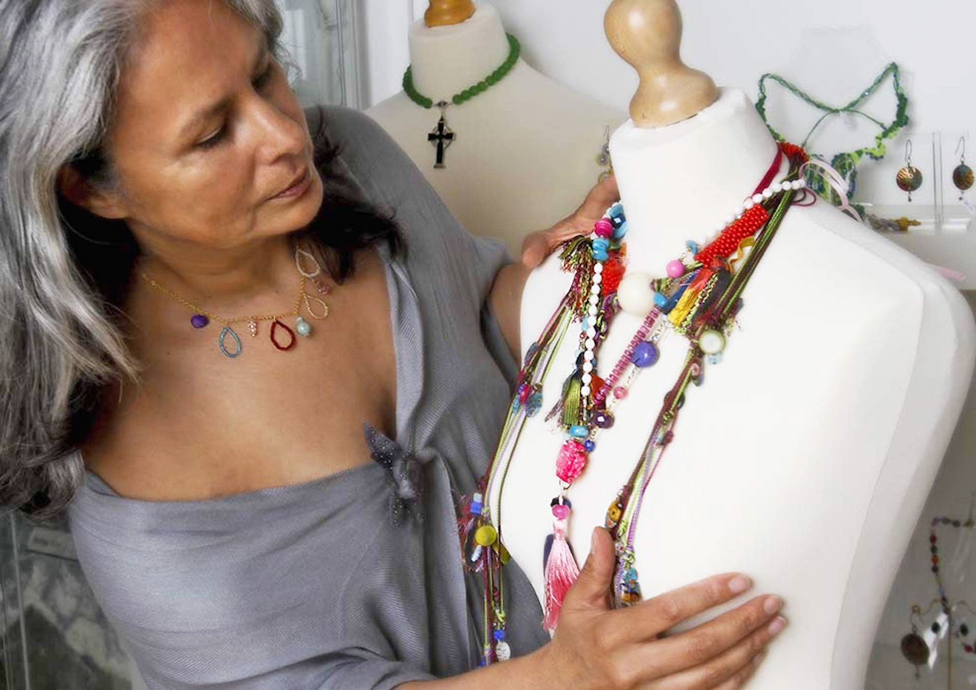 Jewellery Making with Victoria Foutz view of the artist with necklaces of colourful and varied materials