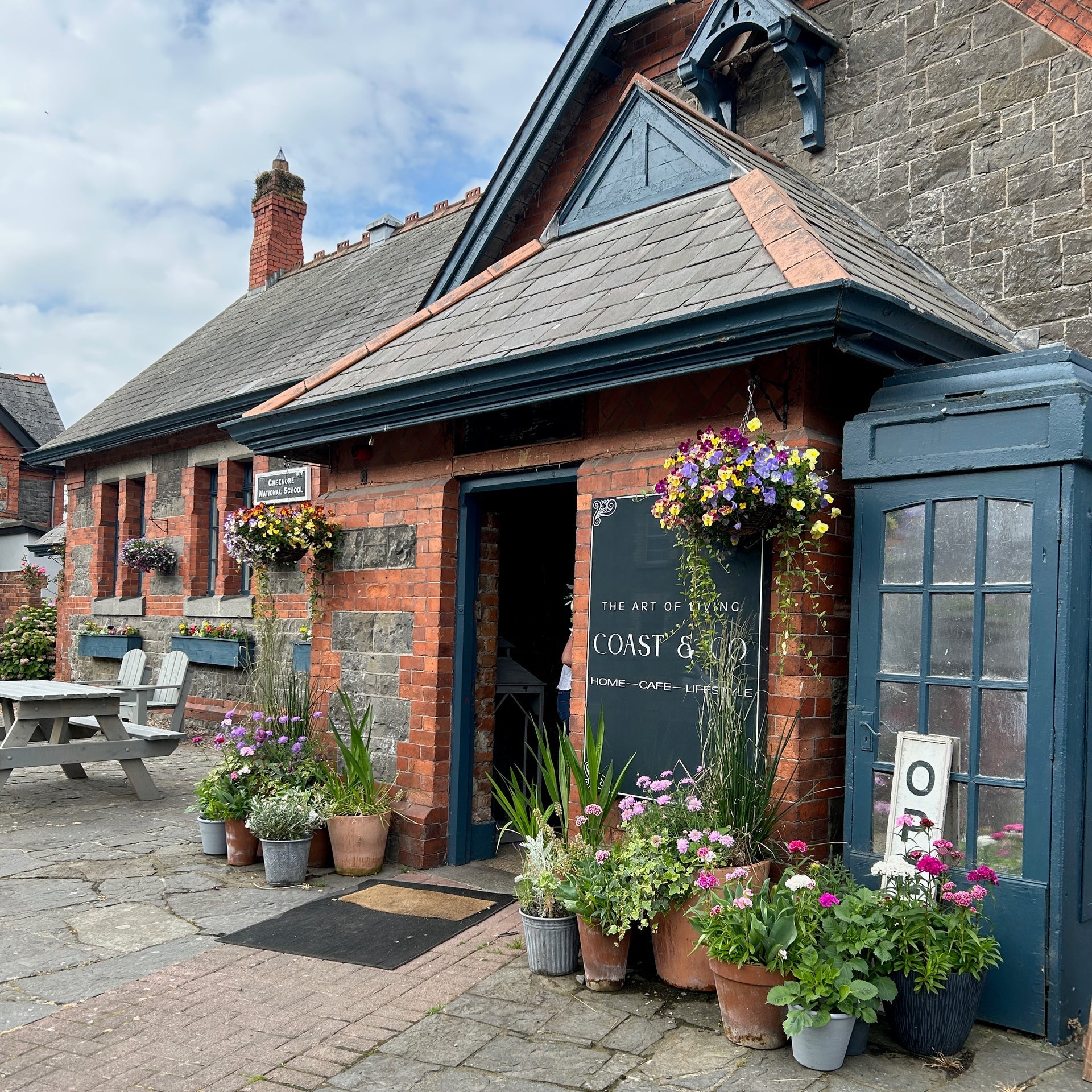 The main entrance to Coast & Co with a painted vintage telephone box beside it