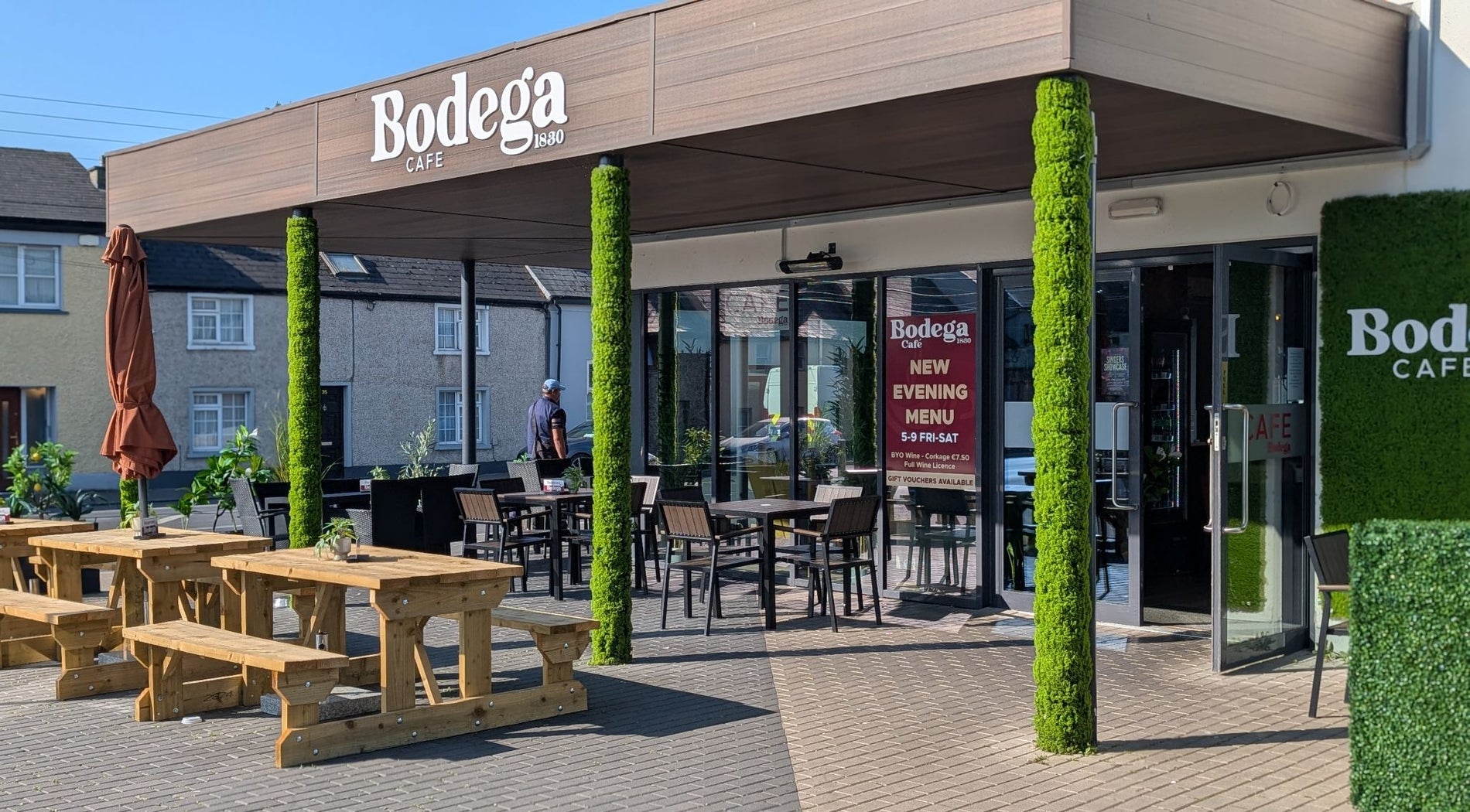 Exterior of a café with a dining area outside the door and on the paved street