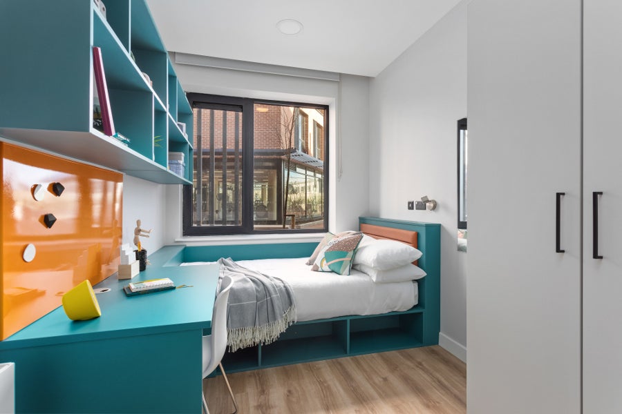 Bedroom with white sheets and seating area