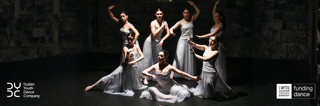 Dancers posed in a still image on a dark background