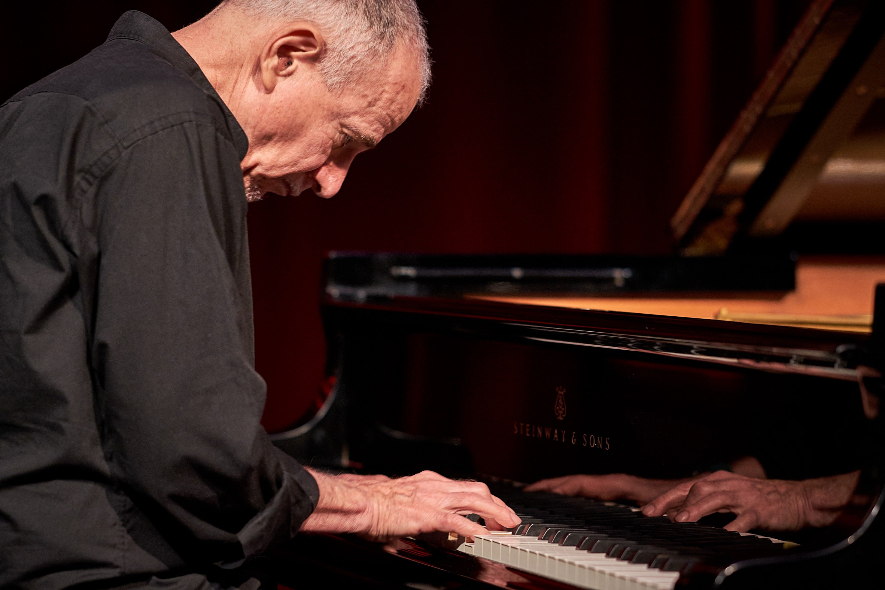 Marc Copland playing a piano.