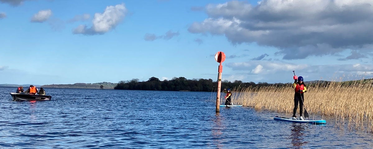Two people out on the water enjoying stand-up paddle boarding