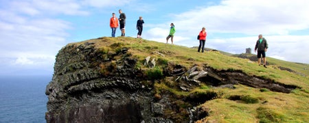 A small group of people standing on a cliff 