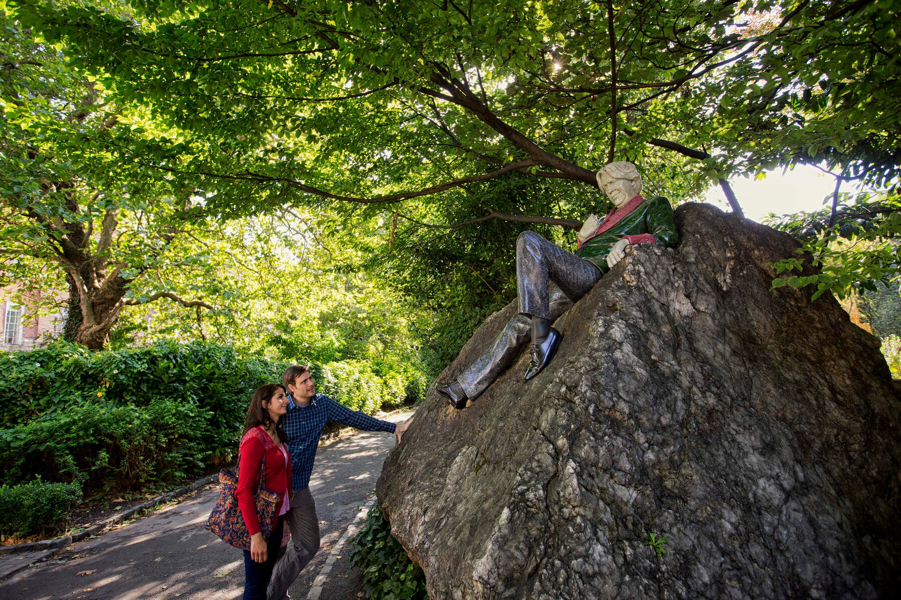 Two people looking at the Oscar Wilde statue in Merrion Square, Dublin.