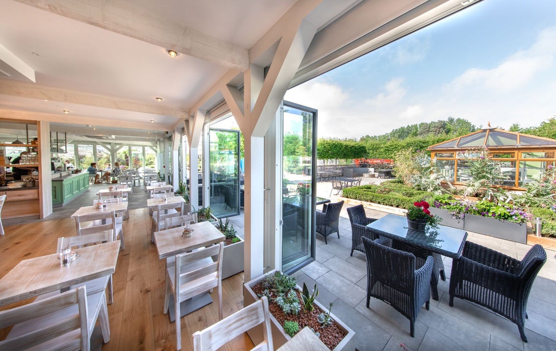 The interior of a café with doors open onto an outdoor terrace