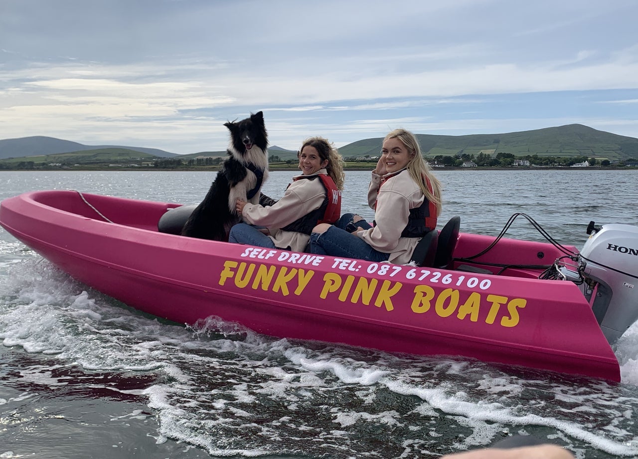Two people in a boat with a dog