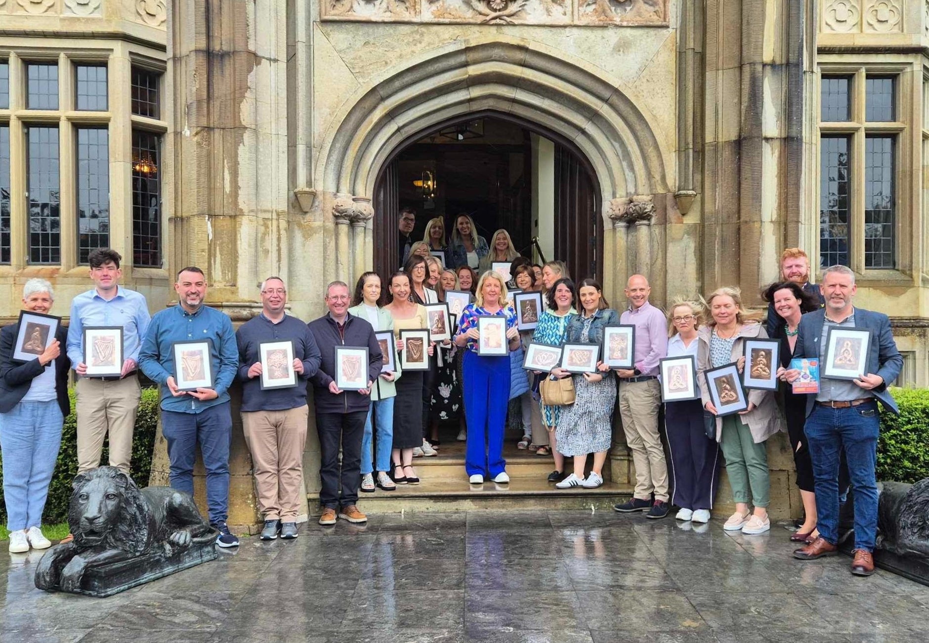 Group of people standing outside a building holding frames