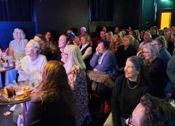An audience laughing in a comedy club