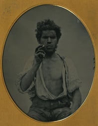 Oval shaped black and white image of a man in a gold coloured frame