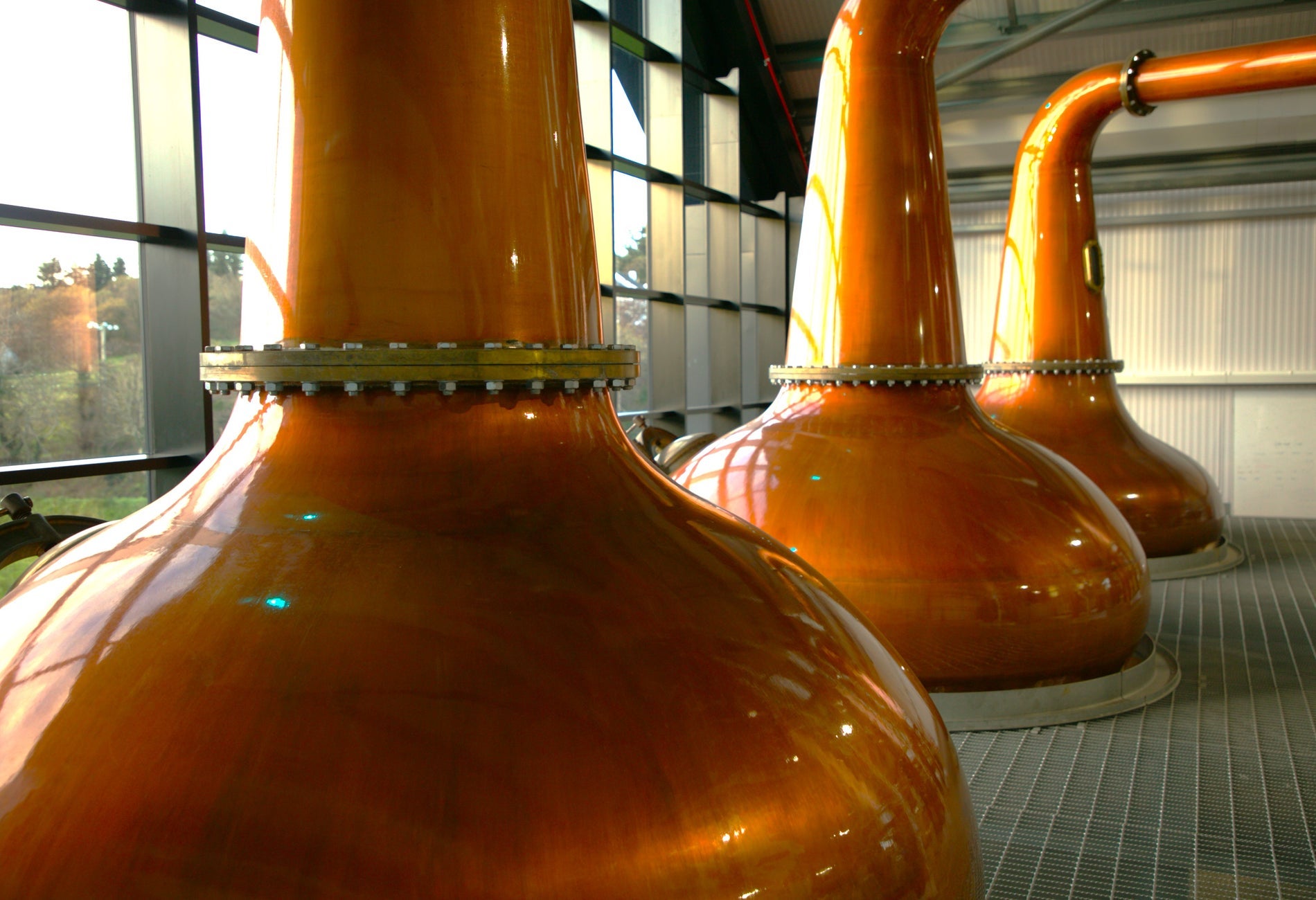 Three copper pot stills on display at The Ardara Distillery