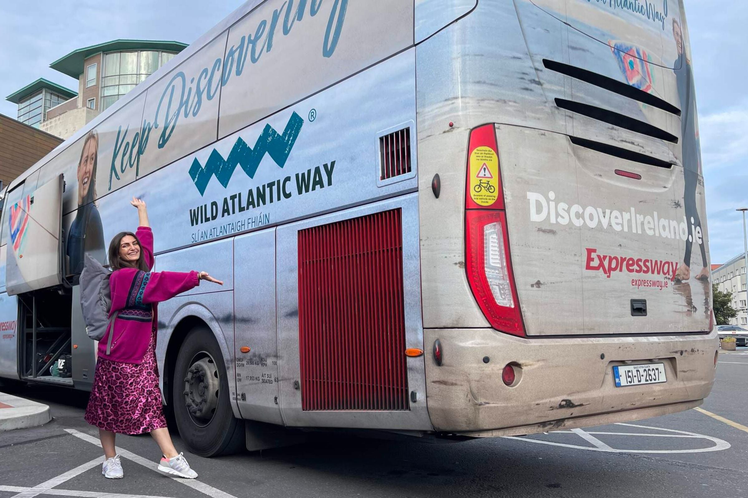 Girl standing in front of a Wild Atlantic Way Expressway bus.