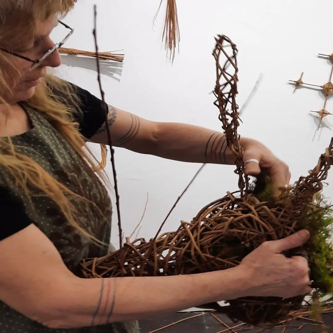 A woman crafting a willow arch at the Bríd Festival in Sligo